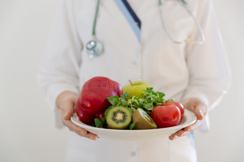 Nutritionist, doctor holding fresh fruit and vegetable, Healthy diet, Nutrition food as a prescription for good health.Weight loss royalty free stock image Nutritionist, doctor holding fresh fruit and vegetable, Healthy diet, Nutrition food as a prescription for good health.Weight loss royalty free stock image