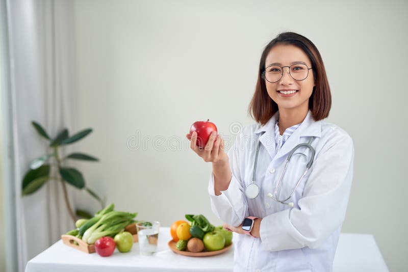 Nutritionistisch bureau met gezond fruit, sap en meettape Dietitian werkt aan een dieetplan op kantoor, glimlachte met de camera royalty-vrije stock fotografie Nutritionistisch bureau met gezond fruit, sap en meettape Dietitian werkt aan een dieetplan op kantoor, glimlachte met de camera royalty-vrije stock fotografie
