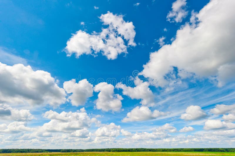 Nuvens bonitas e céu azul sobre o campo e as frentes imagem de stock royalty free Nuvens bonitas e céu azul sobre o campo e as frentes imagem de stock royalty free