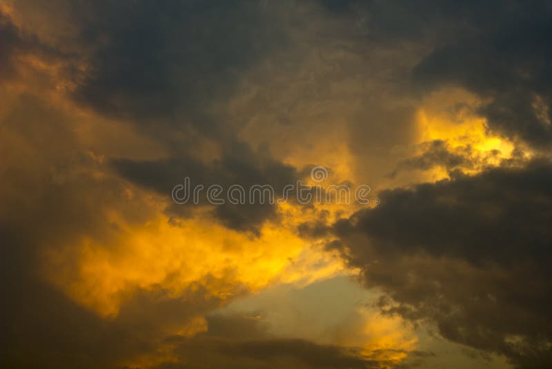 Nuvens de tempestade cinzentas alaranjadas brilhantes em um céu escuro do por do sol Nuvens de chuva no céu imagens de stock royalty free Nuvens de tempestade cinzentas alaranjadas brilhantes em um céu escuro do por do sol Nuvens de chuva no céu imagens de stock royalty free