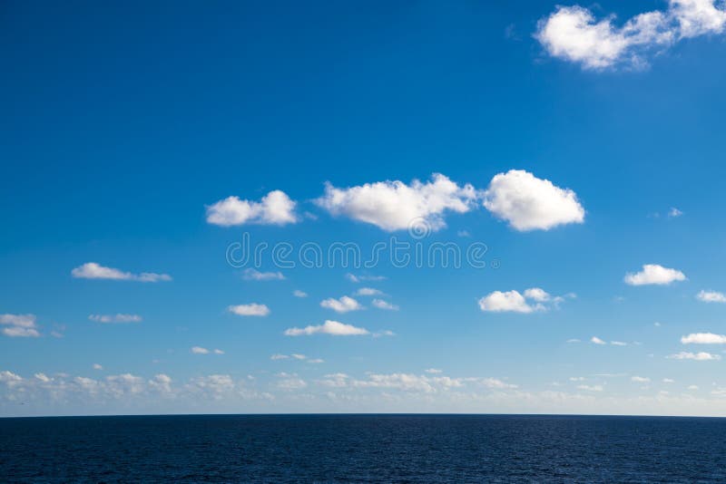 Nuvens perfeitas no céu azul, única nuvem macia no céu brilhante sobre o oceano imagem de stock Nuvens perfeitas no céu azul, única nuvem macia no céu brilhante sobre o oceano imagem de stock