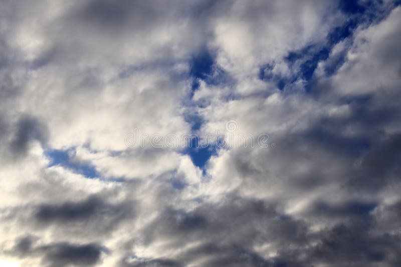 Nuvole di formazione scure su un cielo blu subito prima di una doccia di pioggia immagine stock