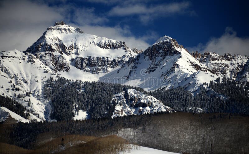 The winter sun casts heavy shadows on the dramatic, tree-flanked crags of the Rocky Mountains in south-western Colorado. The winter sun casts heavy shadows on the dramatic, tree-flanked crags of the Rocky Mountains in south-western Colorado.