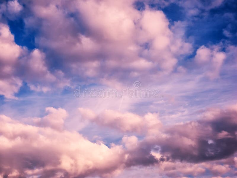 Nuvole gonfie bianche e rosa in cielo blu