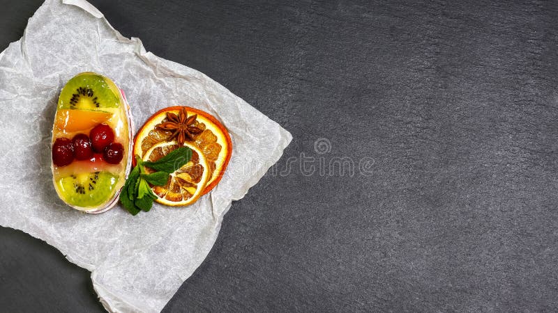 Ny frukt och syrlig efterrätt för bär med duggsocker Läcker söt kaka med kiwin, apelsinen och körsbäret på ett skifferbräde bästa royaltyfri bild Ny frukt och syrlig efterrätt för bär med duggsocker Läcker söt kaka med kiwin, apelsinen och körsbäret på ett skifferbräde bästa royaltyfri bild