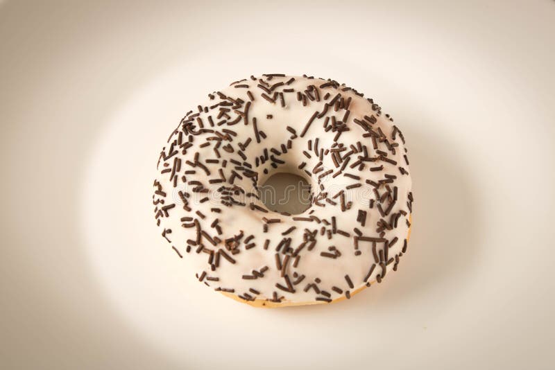 Ny glasad munk med chokladstänk på en vit platta royaltyfri foto Ny glasad munk med chokladstänk på en vit platta royaltyfri foto