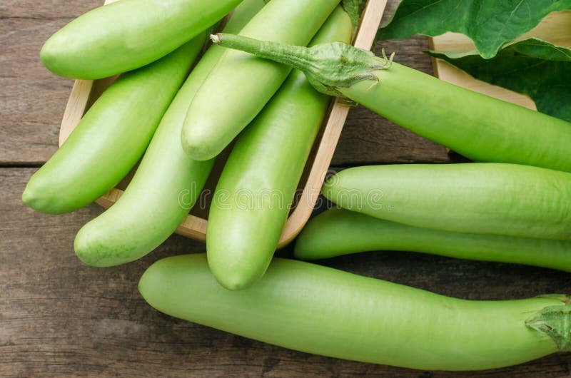 Ny grön aubergine med sidor på trätabellbakgrund arkivbilder Ny grön aubergine med sidor på trätabellbakgrund arkivbilder