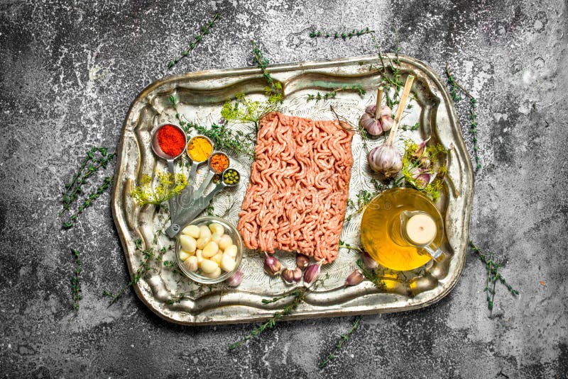 Ny köttfärs med kryddor och örter på ett stålmagasin royaltyfri foto Ny köttfärs med kryddor och örter på ett stålmagasin royaltyfri foto