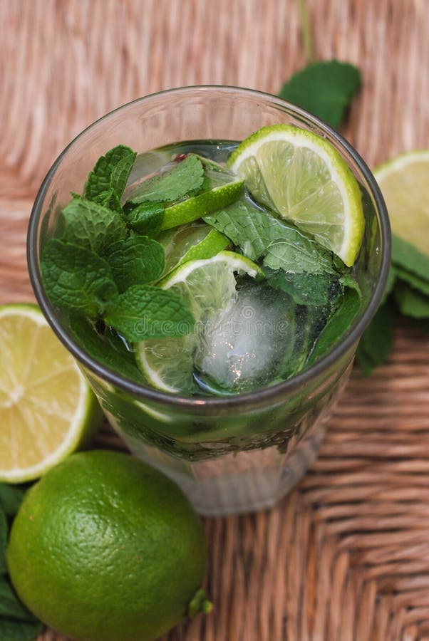Ny Mojito sommarcoctail med citroner och limefrukter och mintkaramellsidor över träbakgrund Lodlinjen avbildar arkivfoto Ny Mojito sommarcoctail med citroner och limefrukter och mintkaramellsidor över träbakgrund Lodlinjen avbildar arkivfoto