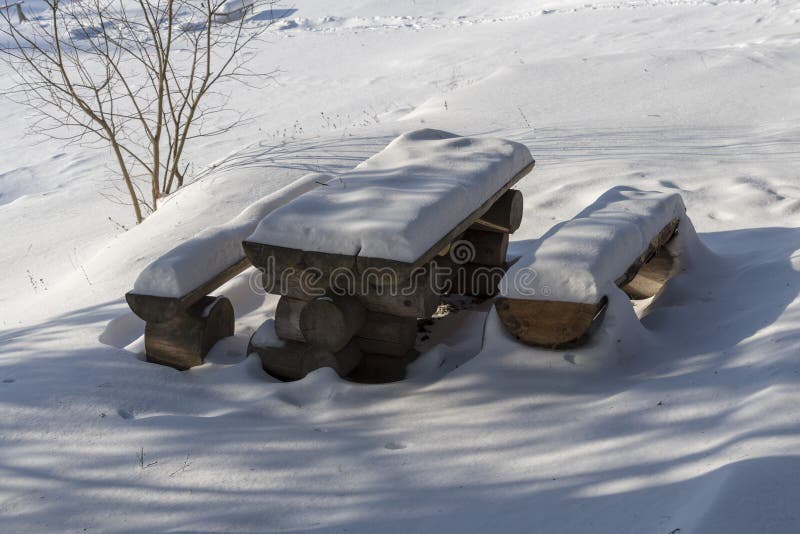 Ny ren snö som täcker brun mahognyträfärg, målade trädgårdstolar och den utomhus- tabellen fotografering för bildbyråer Ny ren snö som täcker brun mahognyträfärg, målade trädgårdstolar och den utomhus- tabellen fotografering för bildbyråer