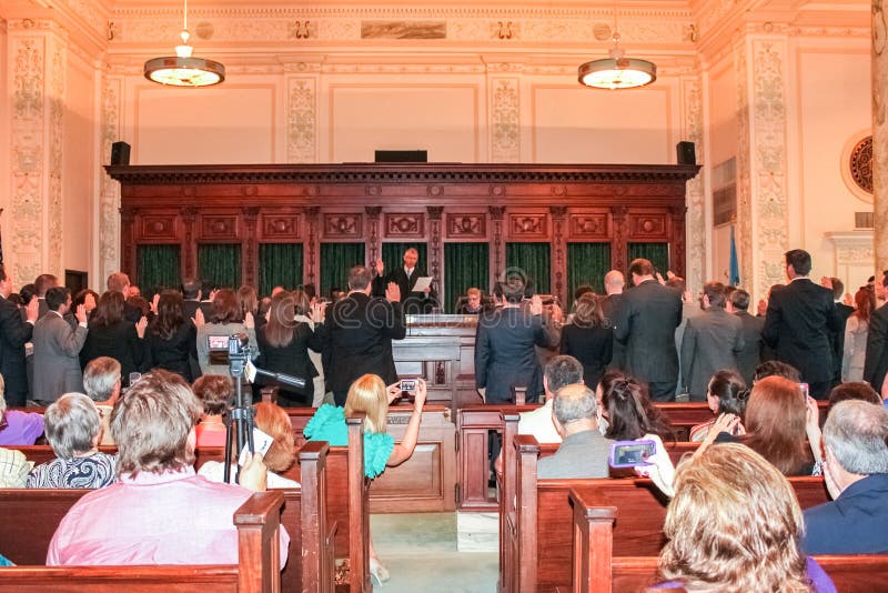 A group of New attorneys being sworn in while friend and family take pictures with cameras and phones Oklahoma City Oklahoma USA May 2 2012. A group of New attorneys being sworn in while friend and family take pictures with cameras and phones Oklahoma City Oklahoma USA May 2 2012