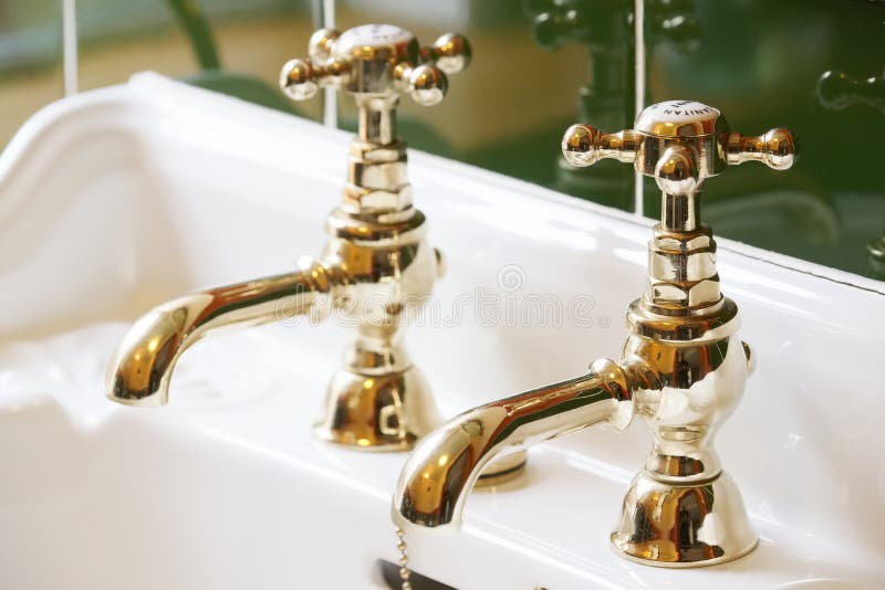 Nya lyxhotell, vintage brass guldplakat stolpar i åtsittande badrum i tvättbassäng