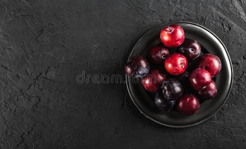 Nya plommoner i platta på mörk stenbakgrund bär fruktt sund sommar royaltyfri foto Nya plommoner i platta på mörk stenbakgrund bär fruktt sund sommar royaltyfri foto