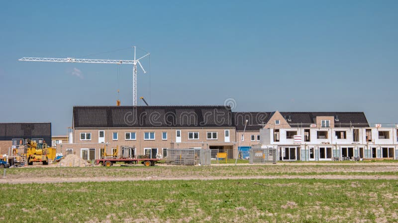 Nybyggda hus med solpaneler på taket mot ett solskum nya byggnader med svarta solpaneler.