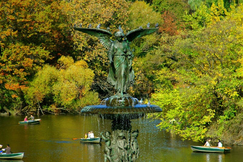 The beautiful angel fountain at the Bethesda Terrace and people in row boats enjoying an early Autumn afternoon in NYC's Central Park on the boating lake. The beautiful angel fountain at the Bethesda Terrace and people in row boats enjoying an early Autumn afternoon in NYC's Central Park on the boating lake.