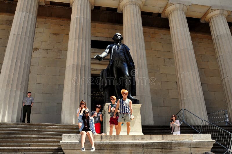 A group of Asian tourists posing by the famed statue of George Washington in front of NYC's historic Federal Hall in Lower Manhattan, the very site where Washington was sworn in as the first President of the USA. A group of Asian tourists posing by the famed statue of George Washington in front of NYC's historic Federal Hall in Lower Manhattan, the very site where Washington was sworn in as the first President of the USA.