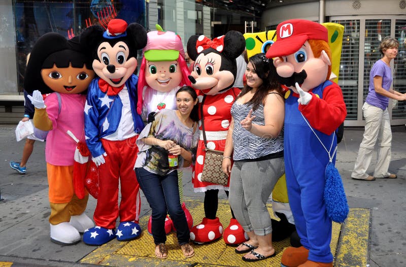 Two tourists pose for a photo with Disney's Mickey and Minnie Mouse and other characters from animated TV shows and films in NYC's Times Square. Two tourists pose for a photo with Disney's Mickey and Minnie Mouse and other characters from animated TV shows and films in NYC's Times Square.