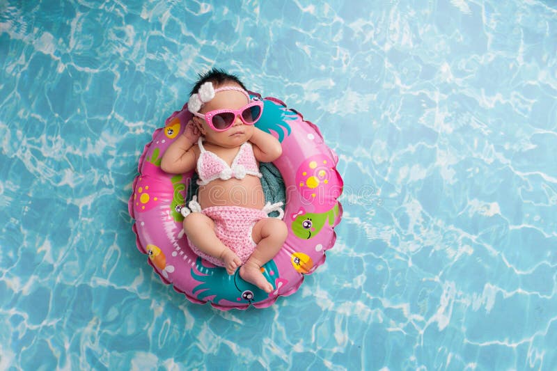 Nyfött behandla som ett barn flickan som bär en bikini och solglasögon arkivbilder