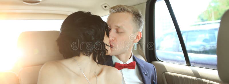 Nygift personpar som kysser i bröllopbillimousine royaltyfri fotografi Nygift personpar som kysser i bröllopbillimousine royaltyfri fotografi