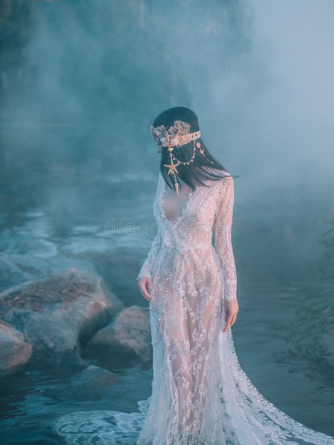Nymphe, promenades en rivière qui a été serrée par un brouillard épais et impénétrable Elle a un vintage blanc, robe de dentelle photographie stock libre de droits Nymphe, promenades en rivière qui a été serrée par un brouillard épais et impénétrable Elle a un vintage blanc, robe de dentelle photographie stock libre de droits