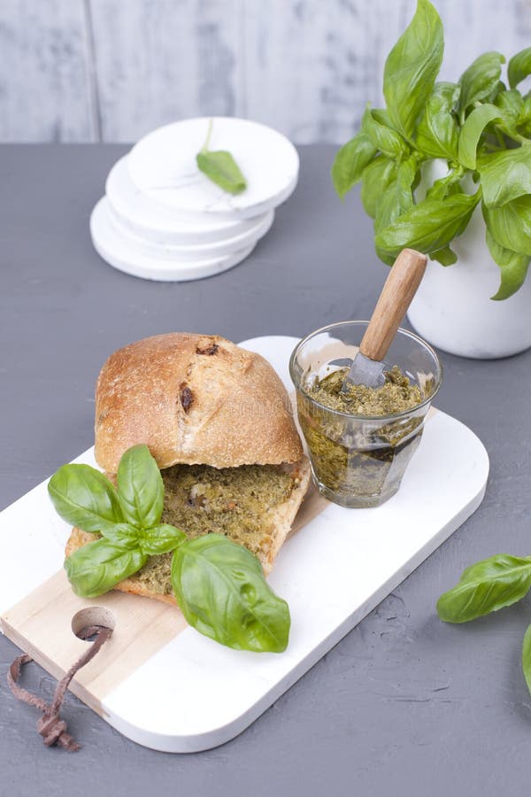 Nytt bröd med pestosås och gräsplanbasilika på det vita brädet läcker sund lunch Fritt utrymme för texten kopiera avstånd arkivfoto Nytt bröd med pestosås och gräsplanbasilika på det vita brädet läcker sund lunch Fritt utrymme för texten kopiera avstånd arkivfoto