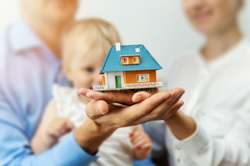 New home concept - young family with dream house scale model in hands. New home concept - young family with dream house scale model in hands
