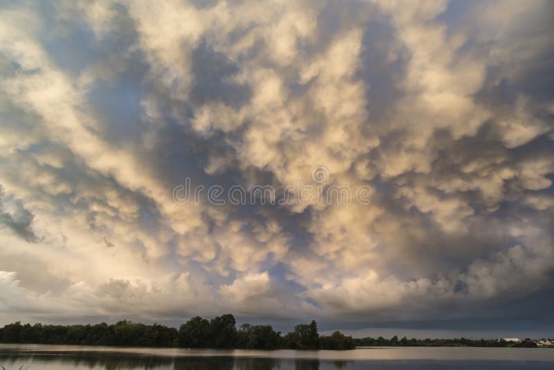När du bedövar dramatisk mammatus fördunklar bildande över sjölandskap fotografering för bildbyråer