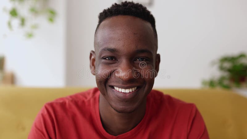 Nära ansikte porträtt av ung afrikan man som leker i kameran lager videofilmer
