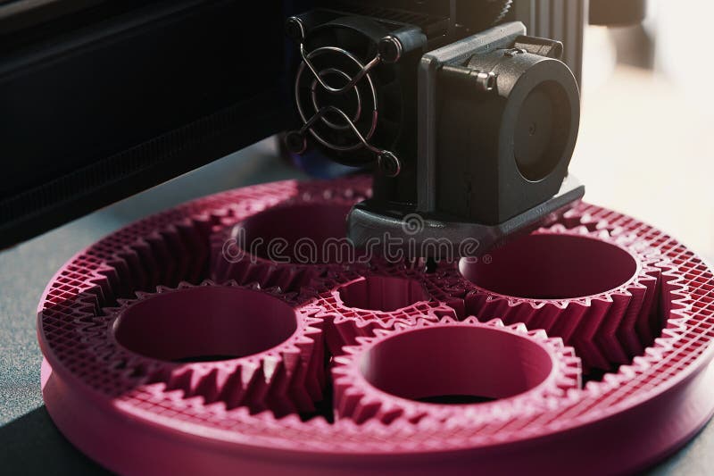 Nära den tryckta överdelen av 3D-skrivaren som gör en planetär växel från rosa plastprodukter. royaltyfri bild