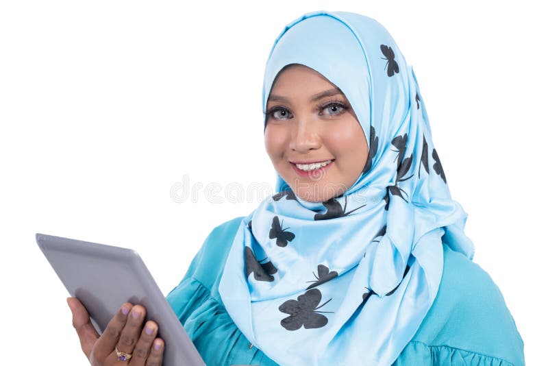 Nära en vacker hijab-kvinna med ett leende som håller en digital tablett och tittar på en kamera arkivbilder
