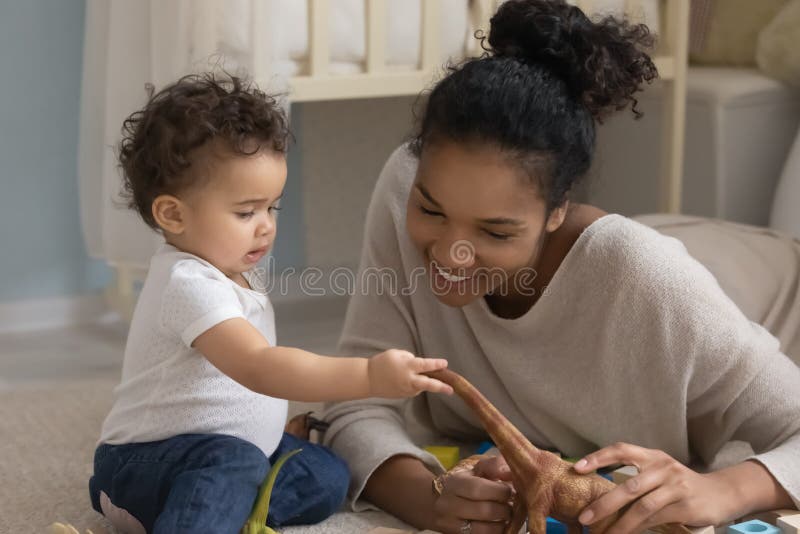 Nära leende afrikansk amerikansk mor och små leksaker