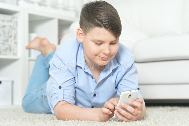 Nära porträtt av glad ung pojke med smartphone arkivbilder