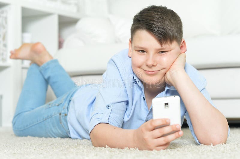 Nära porträtt av ung pojke med smartphone arkivbilder