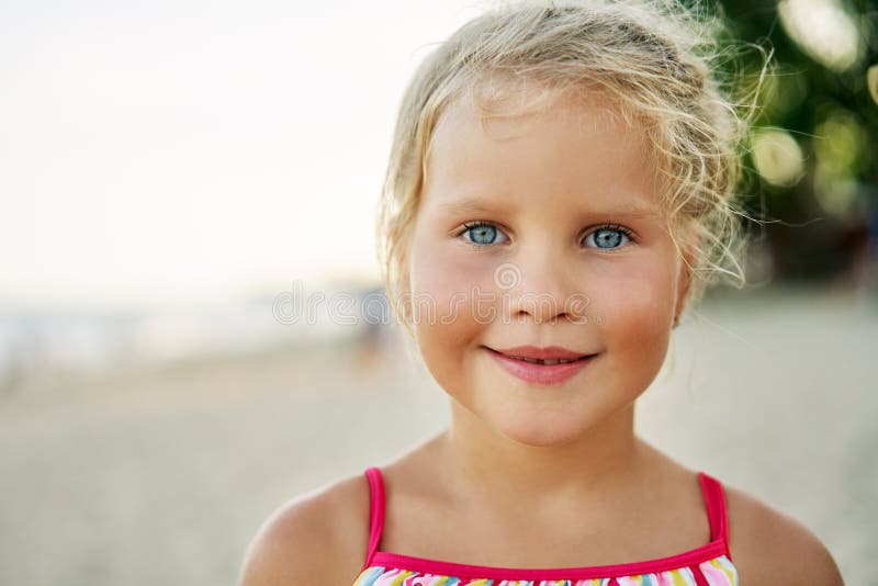 Nära övre stående av den lyckliga gulliga lilla flickan Le det blonda barnet på sommar royaltyfria bilder Nära övre stående av den lyckliga gulliga lilla flickan Le det blonda barnet på sommar royaltyfria bilder
