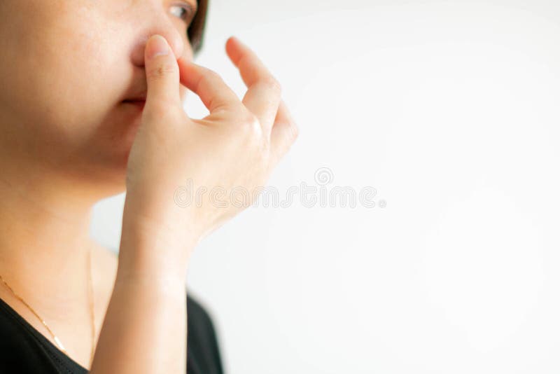 Närbild av den caucasian kvinnabrukstummen och pekfingerrazzia hennes näsa när dålig lukt för doft