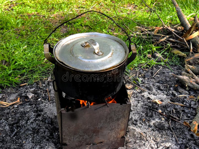 Närbild av en campa panna för att laga mat fisksoppa som fångades på betet med en härlig landskapbakgrund royaltyfria foton Närbild av en campa panna för att laga mat fisksoppa som fångades på betet med en härlig landskapbakgrund royaltyfria foton