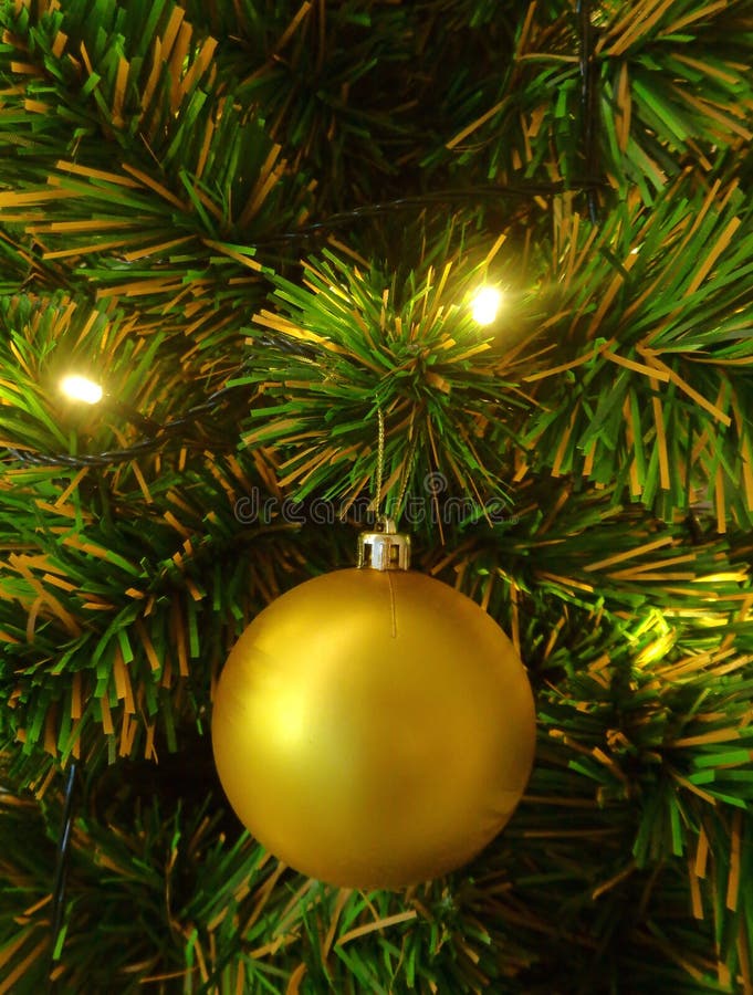 Närbild av en guld- skinande bollprydnad på julgranen, vertikalt foto fotografering för bildbyråer Närbild av en guld- skinande bollprydnad på julgranen, vertikalt foto fotografering för bildbyråer
