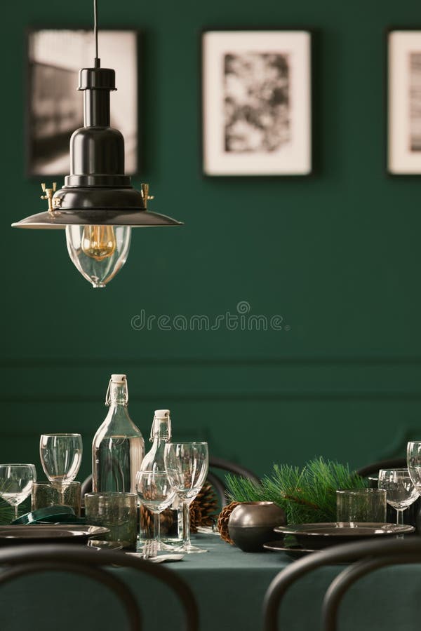Närbild av en metalllampa som hänger ovanför en elegant tabell med den gröna torkduken Suddig vägg med foto i bakgrunden Verkligt arkivbilder Närbild av en metalllampa som hänger ovanför en elegant tabell med den gröna torkduken Suddig vägg med foto i bakgrunden Verkligt arkivbilder