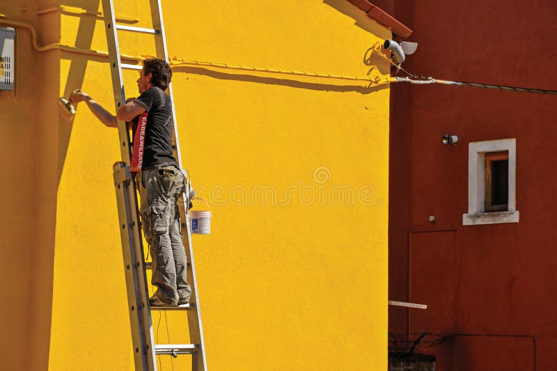Närbild av målaremålningväggen av huset av guling i Burano royaltyfri fotografi Närbild av målaremålningväggen av huset av guling i Burano royaltyfri fotografi
