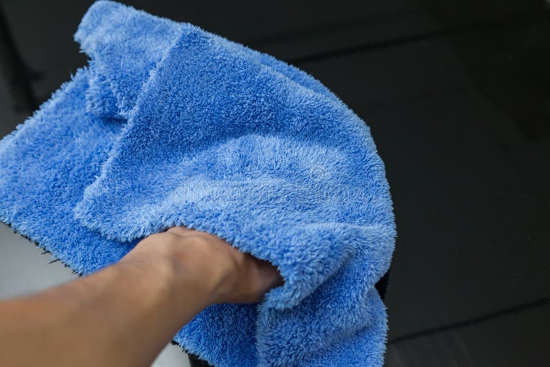 Närbild på handen av ett manligt rengöringsmedel med en blå microfibertorkduk som torkar en svart bil, når tvätt och det har appl fotografering för bildbyråer Närbild på handen av ett manligt rengöringsmedel med en blå microfibertorkduk som torkar en svart bil, når tvätt och det har appl fotografering för bildbyråer