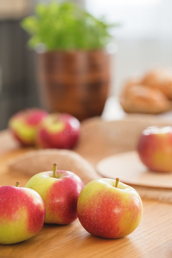 Närbild på röda och gröna äpplen på trätabellen i matsal som är inre med sund mat Verkligt foto