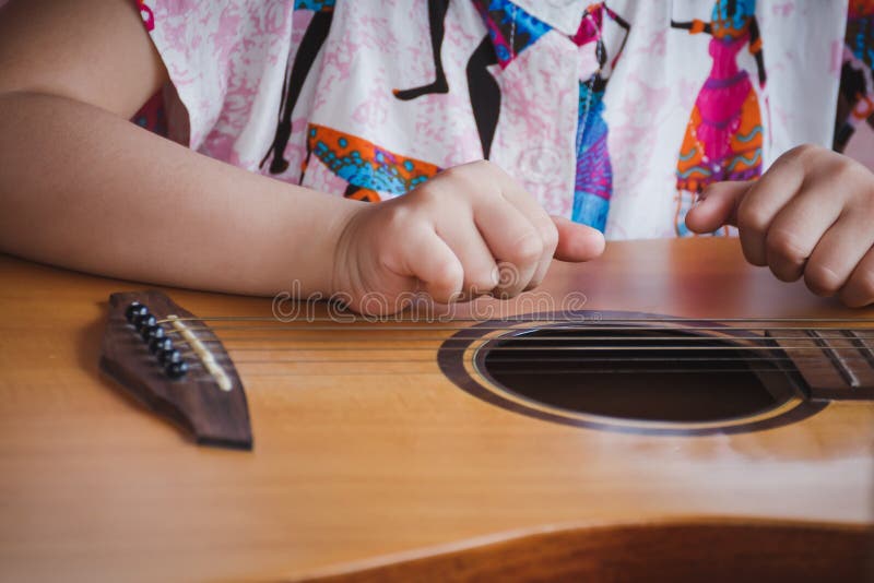 Närbildbarn som spelar gitarren Begrepp av liftstyle, att lära, hobbyen, musikern, drömmen och fantasi arkivbilder Närbildbarn som spelar gitarren Begrepp av liftstyle, att lära, hobbyen, musikern, drömmen och fantasi arkivbilder