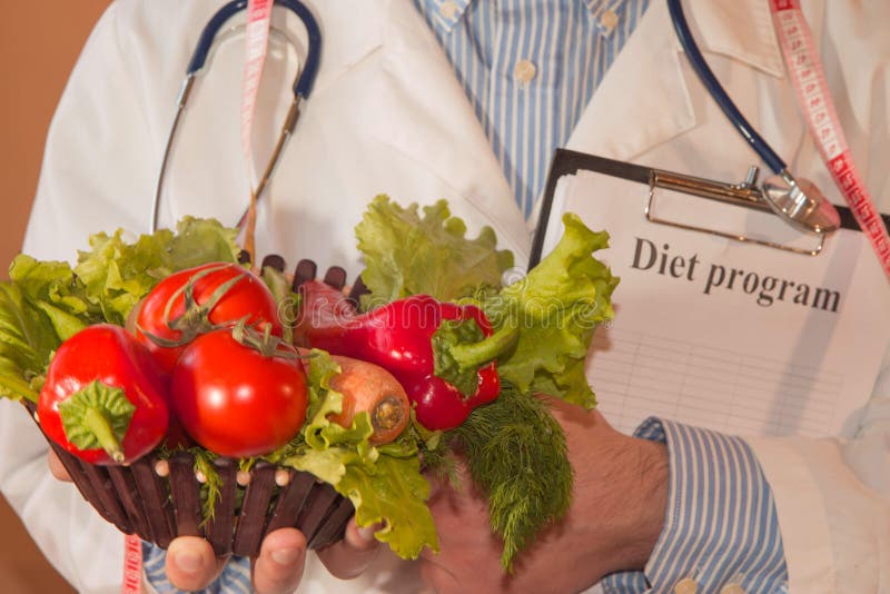 Närbilden av den manliga näringsfysiologen räcker att mäta grönsaker med bandet Stående av den manliga dietisten With Fresh Veget fotografering för bildbyråer Närbilden av den manliga näringsfysiologen räcker att mäta grönsaker med bandet Stående av den manliga dietisten With Fresh Veget fotografering för bildbyråer