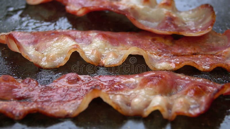 Närbilden av en skiva av bacon stekte på galler