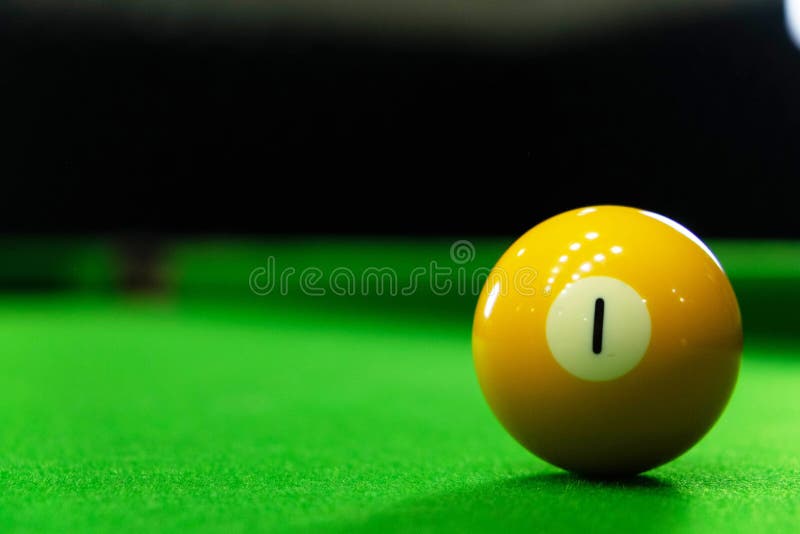 Närbildfoto av billiardbollen, nummer 1 och det gröna golvet arkivfoto Närbildfoto av billiardbollen, nummer 1 och det gröna golvet arkivfoto