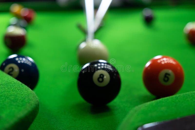 Närbildfoto som spelar billiardbollar, olika nummer som sticker bollen, numren och den gröna jordningen royaltyfri foto Närbildfoto som spelar billiardbollar, olika nummer som sticker bollen, numren och den gröna jordningen royaltyfri foto