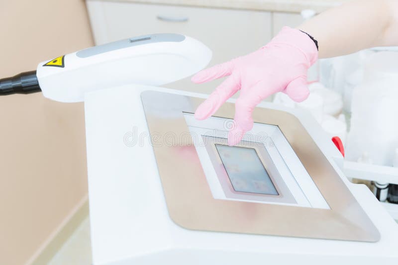 Närbildung flickakosmetologen inkluderar en apparat för kollokalvård på pekskärmen i kontoret av cosmetology royaltyfri foto Närbildung flickakosmetologen inkluderar en apparat för kollokalvård på pekskärmen i kontoret av cosmetology royaltyfri foto