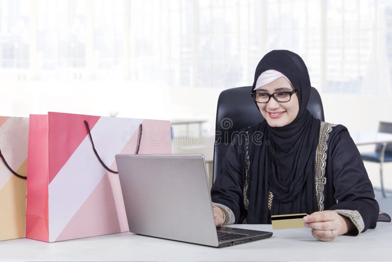 Nätt arabisk kvinna som direktanslutet shoppar arkivfoto Nätt arabisk kvinna som direktanslutet shoppar arkivfoto