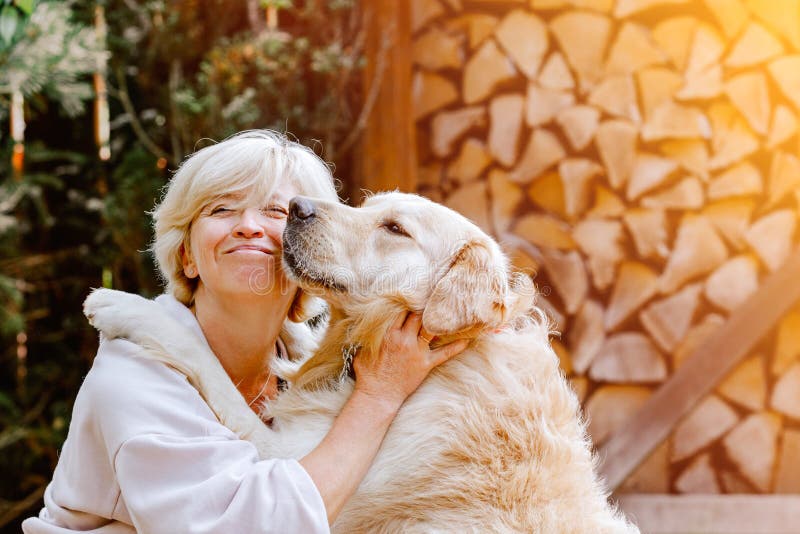 Nätt blond kvinna som spelar med hennes hundgolden retriever arkivbilder Nätt blond kvinna som spelar med hennes hundgolden retriever arkivbilder