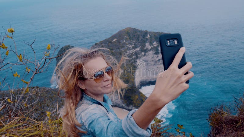 Nätt flickahandelsresande på den Kelingking stranden i Nusa Penida, Bali arkivfoto Nätt flickahandelsresande på den Kelingking stranden i Nusa Penida, Bali arkivfoto